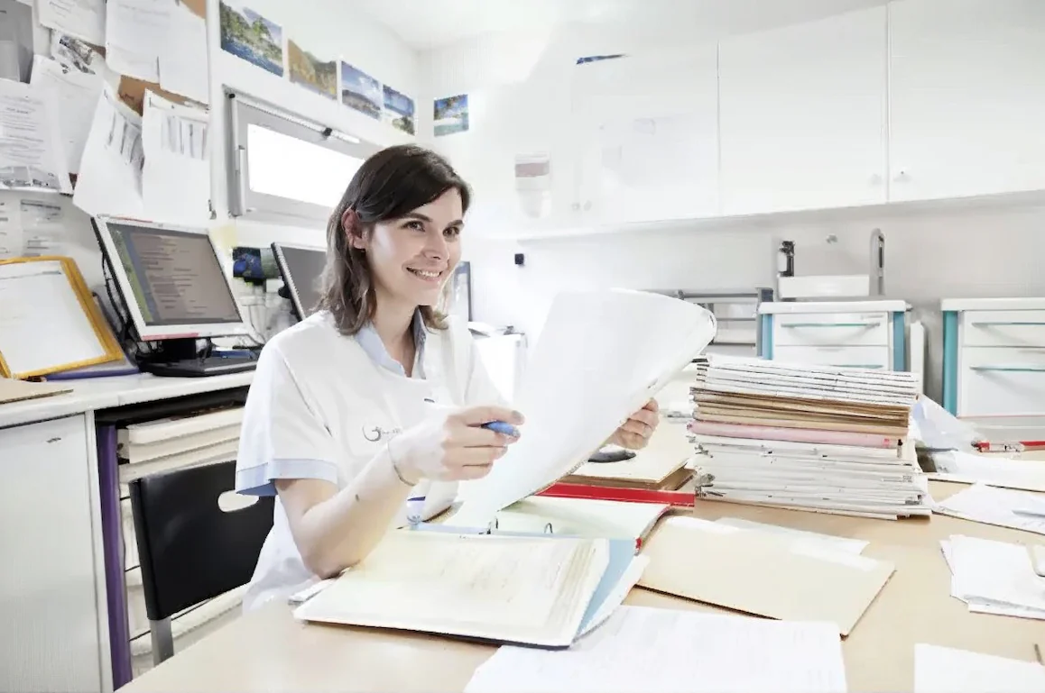 Secrétaire médicale souriante consultant des dossiers patients