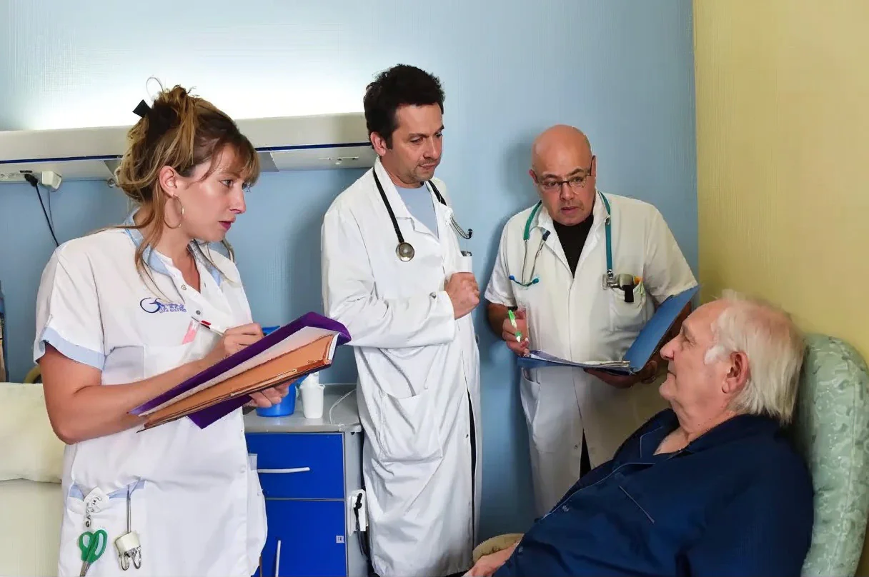 Infirmière et médecins au chevet d'un patient âgé