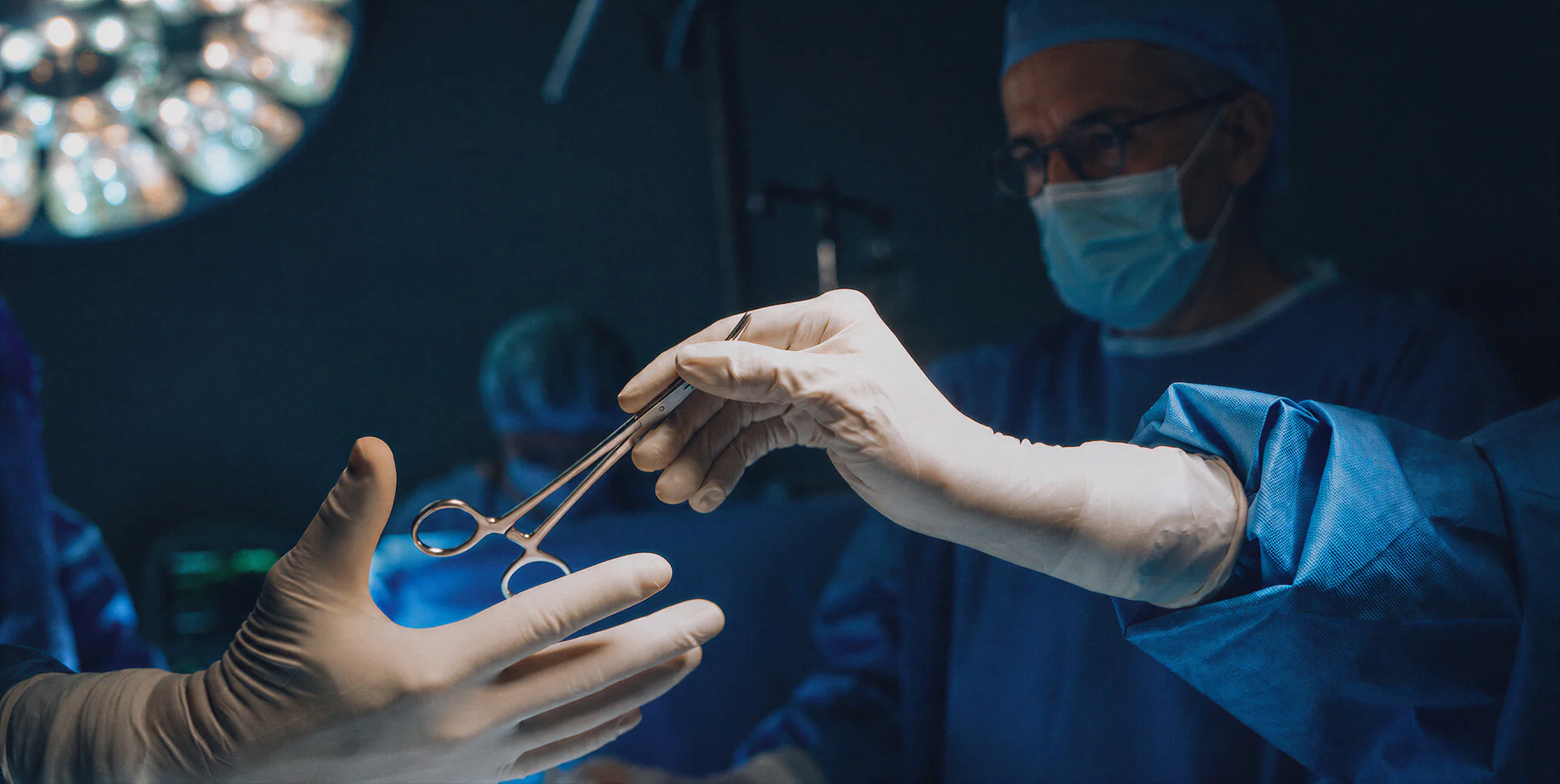 Transmission d'un instrument chirurgical entre deux mains gantées au bloc opératoire